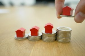 Homes on stacked coins depicting increasing equity.