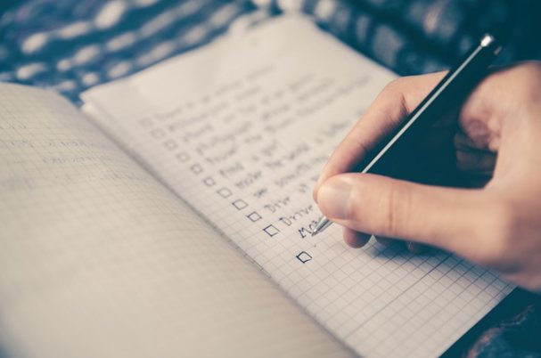 Year-End Financial Planning Checklist with hand and pen.