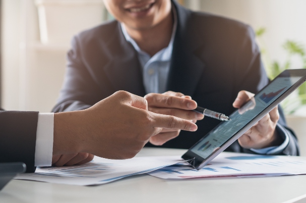 Advisor vs. Adviser: What’s the Big Deal depicts photo of advisors looking at tablet.