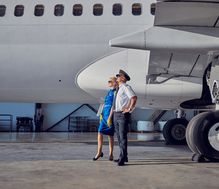 Financial planning for airline professionals concept image with captain with flight attendant enjoying good weather in the airport.