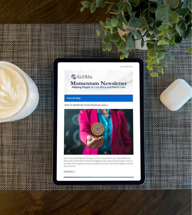 Your Money Momentum Newsletter can be seen in a tablet sitting on a table with a mug of coffee next to it.