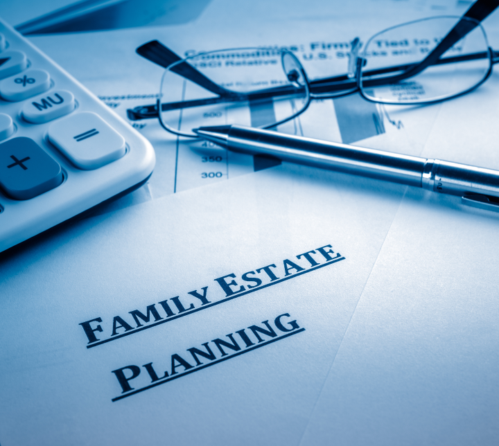 Estate planning concept of calculator, reading glasses and pen sitting on top of estate documents.