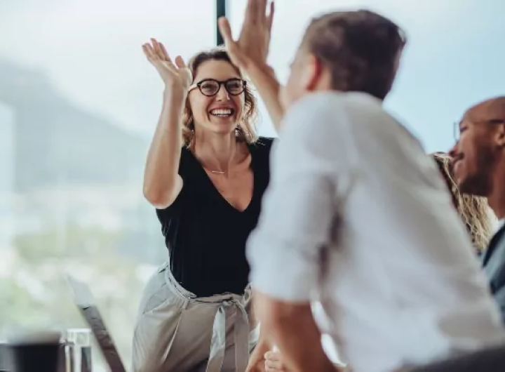 Employee retirement plan management for small business owners concept with business people giving each other a high-five.