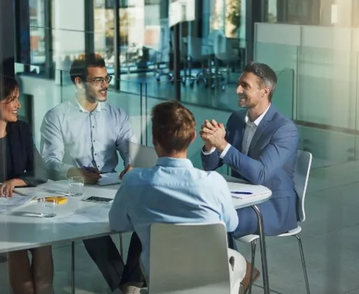 Financial wellness program concept with corporate team members talking around a conference table.