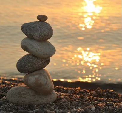 Aging and dementia concept image of rocks stacked next to a body of water.