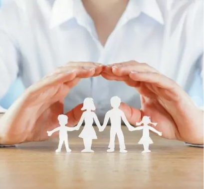 Estate planning guide concept of an advisor covering paper cutouts of a family with his hands.