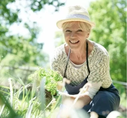 Printable retirement readiness checklist concept photo with an elderly woman crouched down in the garden planting.