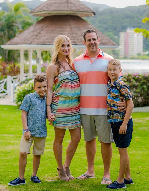 Kris Maksimovich family with tropical locale backdrop.