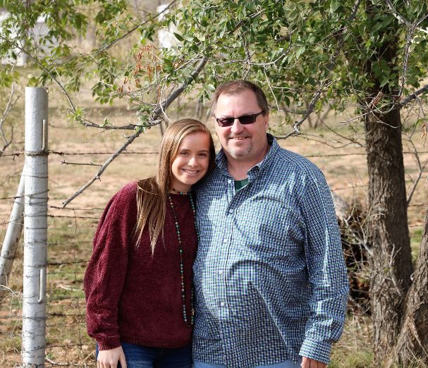 Ben and daughter in front of the family cattle farm.